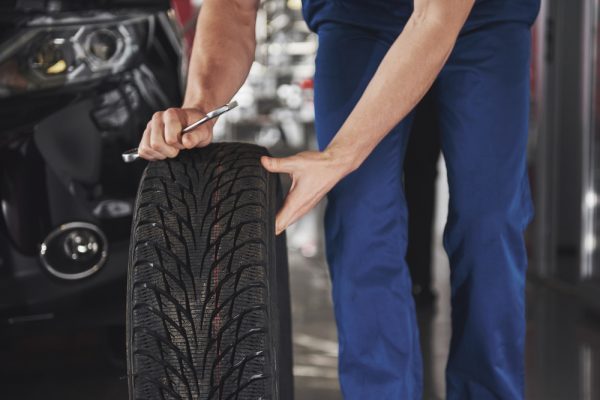Close up of mechanic showing ok gesture with his thumb while holding a wrench.